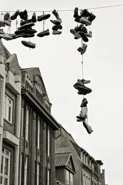 Siyah-beyaz görüntü, Shoefiti, Almanya 'da Luneburg şehir merkezinde asılı ayakkabılar.