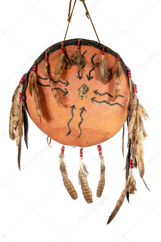 Shield of the North American Indians made of rawhide, painted and adorned with feathers, isolated on white