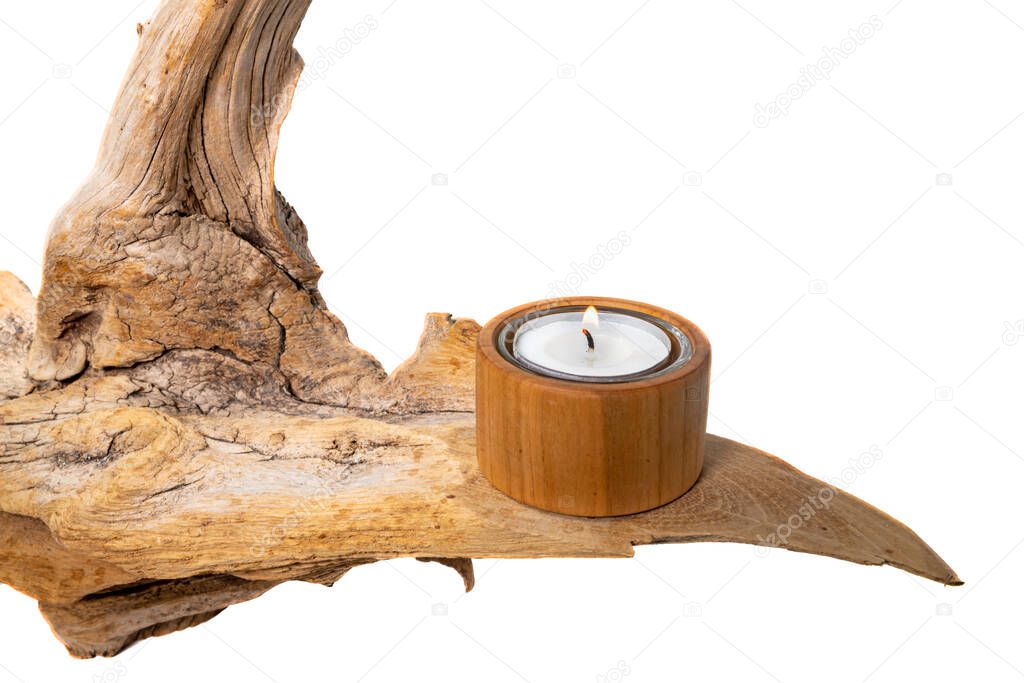 Burning tealight stands on a light tree root, isolated on white as a decoration