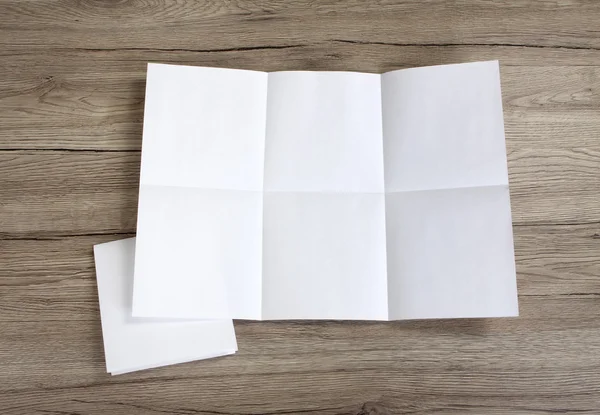 Закрыть помятый разложенный лист бумаги на деревянной подложке — стоковое фото