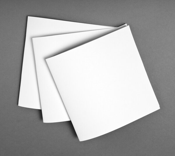 Blank opened magazine isolated on grey background with soft shadows.