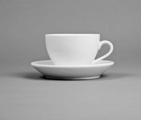 White mug and saucer on a gray background. — Stock Photo, Image