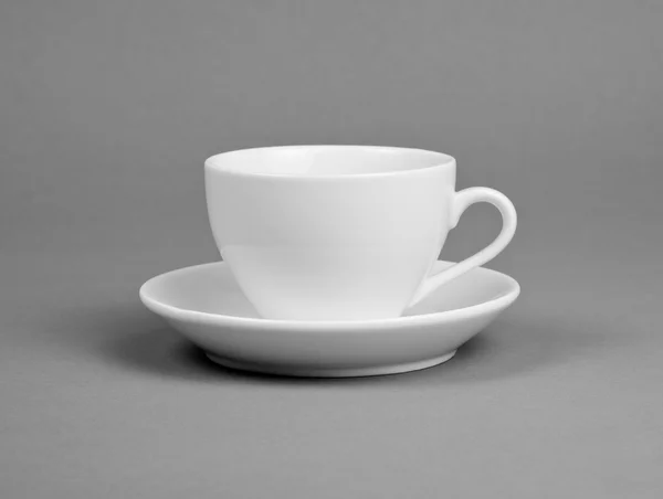 White mug and saucer on a gray background. — Stock Photo, Image