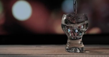 Barmen shot bardaklarına votka / tekila dolduruyor.