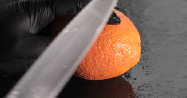 Männerhände Mit Einem Messer Das Orange Auf Dem Schneidebrett Schneidet — Stockvideo