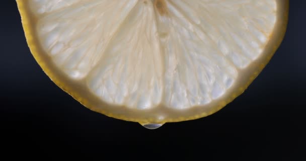 Eine Halbe Zitrone Auf Schwarzem Hintergrund Mehrere Tropfen Saft Fallen — Stockvideo