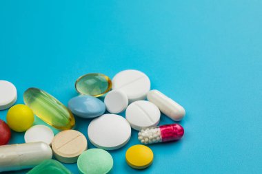 Mavi arka planda çok renkli tabletler. Sağlık hizmeti kavramı