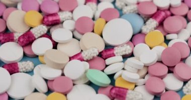 Değişik boyutlarda ve şekillerde çok renkli haplar ve kapsüller dönüyor. 