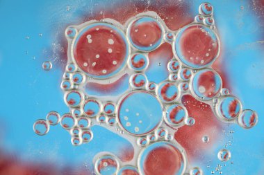 Su üzerindeki yağ baloncukları cam tankta soyut biçimdedir.