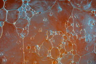 Su üzerindeki yağ baloncukları cam tankta soyut biçimdedir.