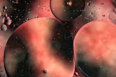 Su üzerindeki yağ baloncukları cam tankta soyut biçimdedir.