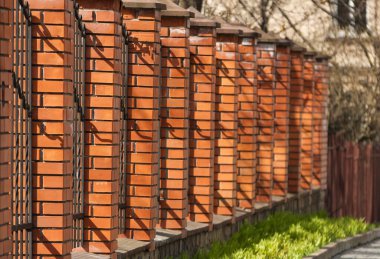 Tuğla sütunlu yüksek çitler. Dekoratif çit