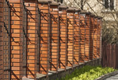 Tuğla sütunlu yüksek çitler. Dekoratif çit