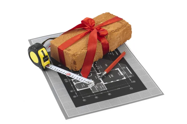 A measuring tape, brick and a pencil over a construction drawing — Stock Photo, Image