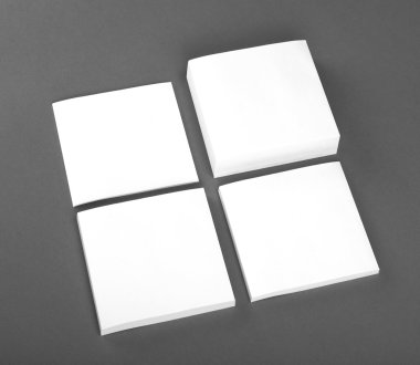 Gri arka plan üzerine beyaz Not kağıtları topluluğu.