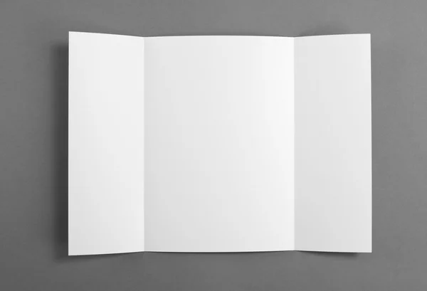 Folleto de pliegue de puerta en blanco sobre gris para reemplazar su diseño . —  Fotos de Stock