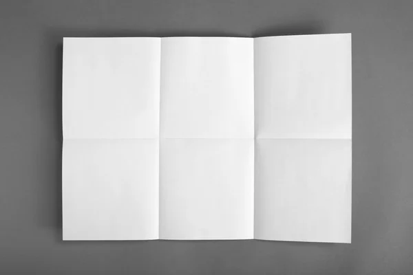 Primer plano de un trozo de papel desdoblado sobre fondo gris — Foto de Stock