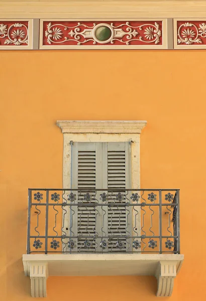 Fasáda domu s balkónem, zavřené okenice a ornamentální štuky — Stock fotografie