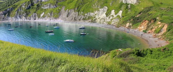 Lulworth cove with boats in blue water — Stock Photo, Image