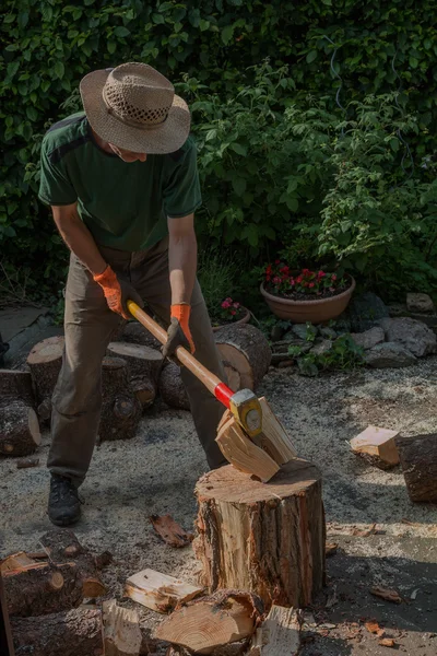 Homme préparant du bois de chauffage avec un coin de séparation — Photo