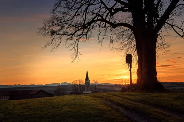 Hügel mit Baum und Wegkreuz, traumhafte Sonnenuntergangskulisse — Stockfoto