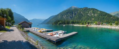 beautiful tourist resort lake Achensee, promenade Achenkirch with boardwalk and boats. tirolean landscape