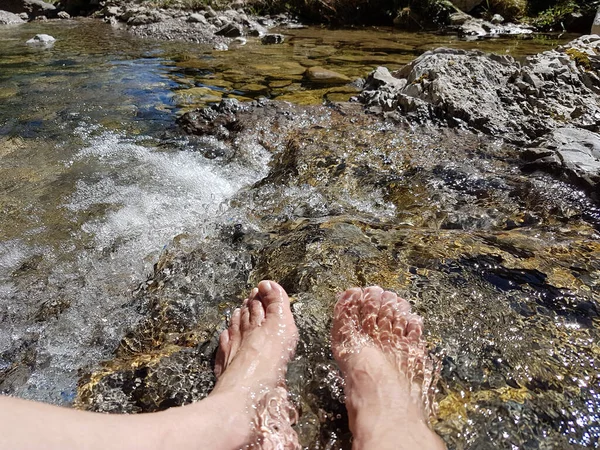 closeup of womans feet, hardening in a cold mountain brook, Kneipp cure