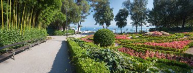 Hırvatistan 'ın Opatija kentinde deniz kenarında bambu, buxus ve begonya çiçekli spa bahçesi. Deniz kıyısındaki turistik tatil beldesi