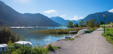 idyllic lake shore Achensee Buchau, with boats at the water, mountain view tirol, austria