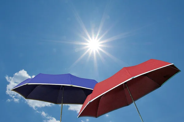 红色和蓝色的伞，明亮晴朗的天空 — 图库照片