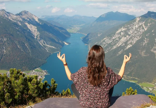 Ung kvinna mediterar på bergets topp — Stockfoto