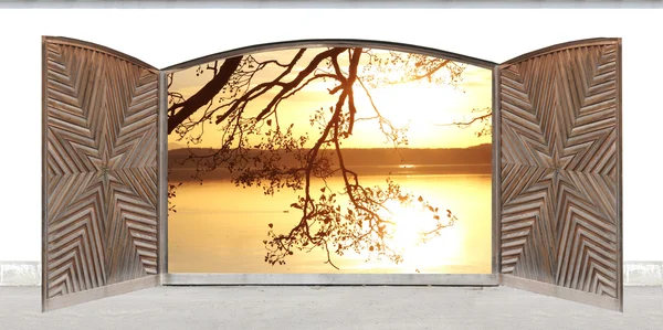 Rzeźbione drewniane drzwi dwuskrzydłowe z widokiem na jezioro o zachodzie słońca — Zdjęcie stockowe