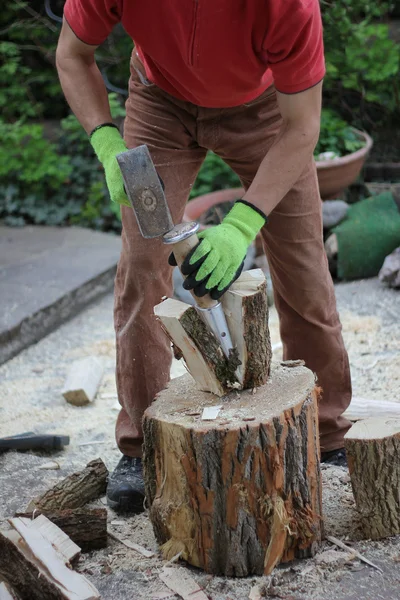 Uomo della lavorazione del legno con zeppa spaccante in giardino — Foto Stock