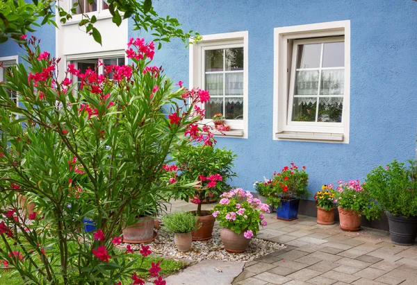 Fronte casa blu con vasi di fiori decorativi mediterranei — Foto Stock
