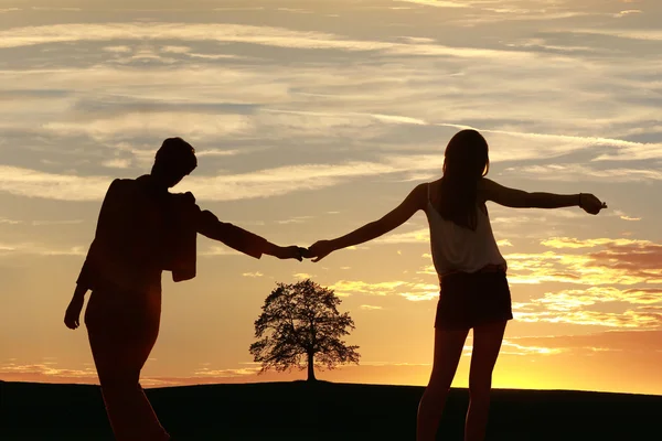 Teenage sisters outdoors - sunset landscape with tree silhouette — Stock Photo, Image