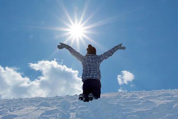 Menina com os braços estendidos largos, ajoelhado na neve — Fotografia de Stock