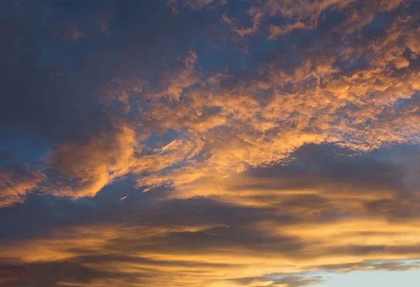 A narancsszínű felhők megvilágított napnyugtakor ég — Stock Fotó