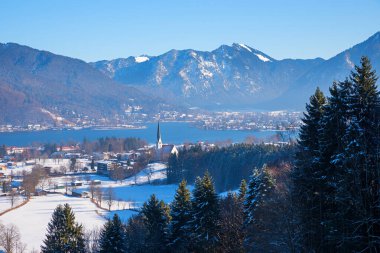 Yukarı Bavyera 'da kış manzarası, Prinzenruhe' dan karlı Wiessee kaplıcalarına kadar kilise ve göl Tegernsee Gölü ile. 