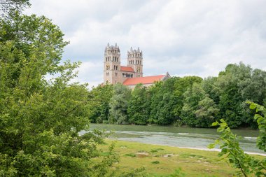 Yeşil nehir bölgesi Isar nehri. Yazın Münih 'teki St. Maximilian kilisesi manzaralı.