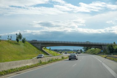 Yukarı Bavyera 'daki A94 otoyolunda bir köprüye doğru sürüyorlar. bulutlu gökyüzü.