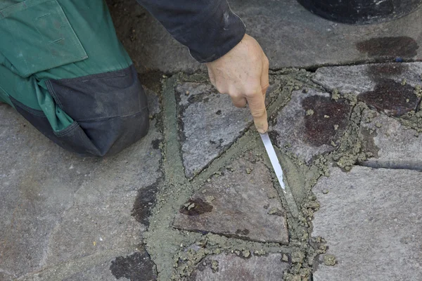 Man grouting porphyry flagstone patio — Stock Photo, Image