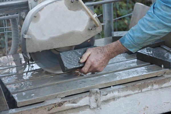 Senior worker cutting tile with a stone saw — Stock Photo, Image