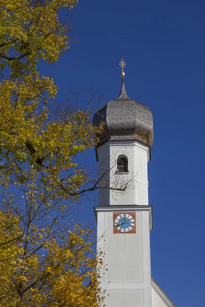 Dorfkirche in Gmund, goldene Buchenblätter und blauer Himmel, bavar — Stockfoto