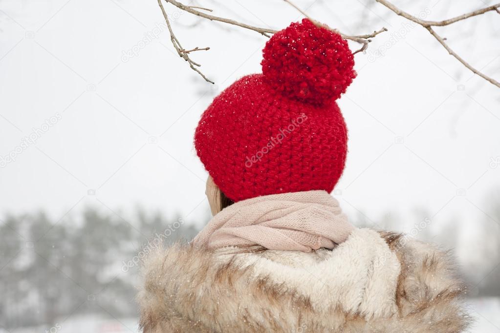 young woman with self crocheted red woollen hat, outdoor