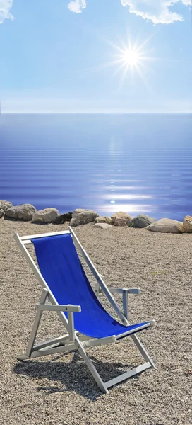 Solarium på steniga stranden, blått vågigt vatten och strålande solsken — Stockfoto