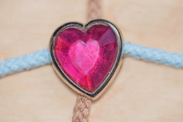 Rosafarbener Herz-Knopf auf Textil-Rändelung — Stockfoto
