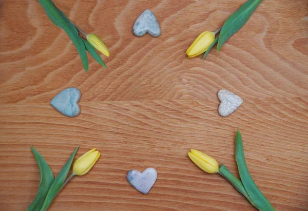 Fond en bois teinté rouge avec des tulipes et des cœurs en stéatite — Photo