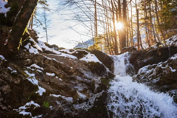 Studené horský potok s kaskádami a jasné slunce — Stock fotografie