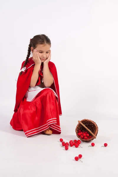 The little girl spilled cherries is sad — Stock Photo, Image