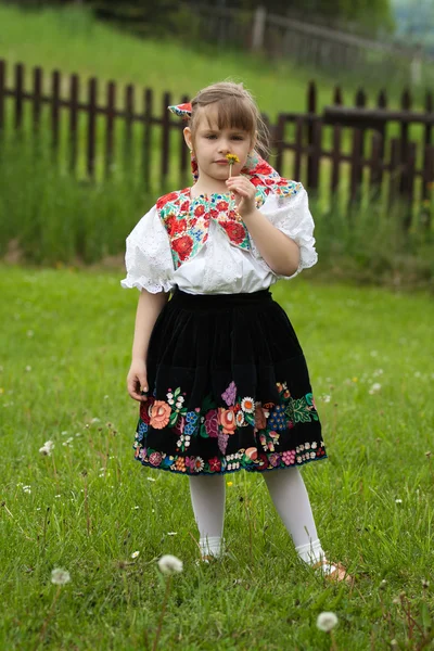 Little girl in traditional costume with flowers — Stock Photo, Image